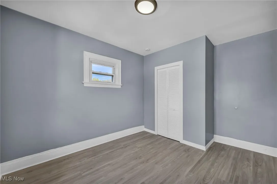 Unfurnished bedroom featuring wood finished floors and a closet