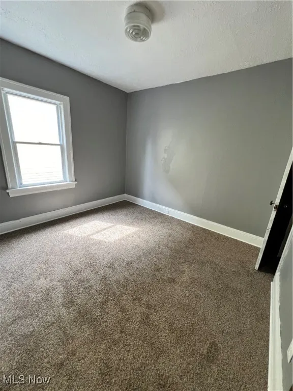 bedroom featuring baseboards and a textured ceiling