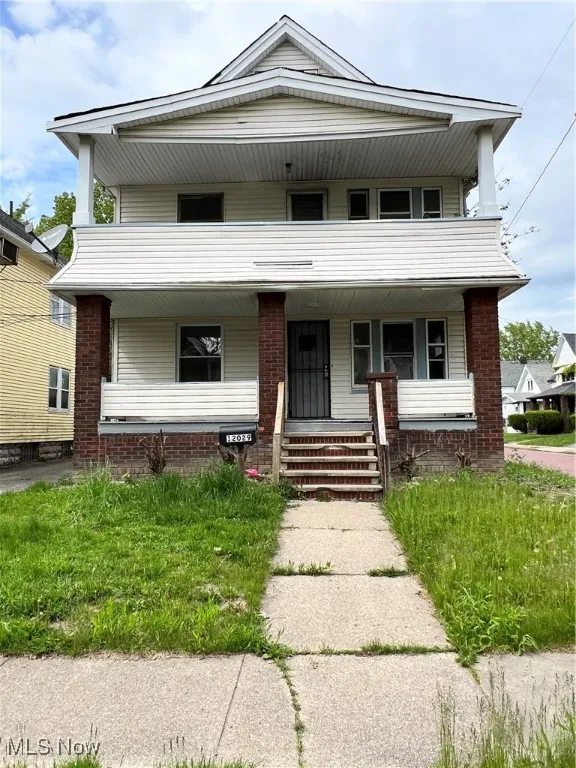 View of front of home featuring covered porch and brick siding