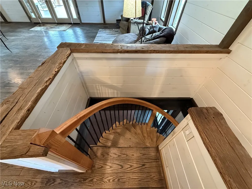 Stairway featuring wood finished floors