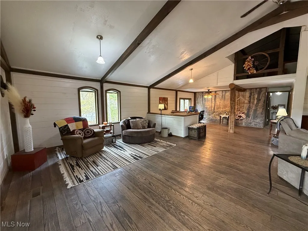 Living room with dark wood-style floors and wood walls