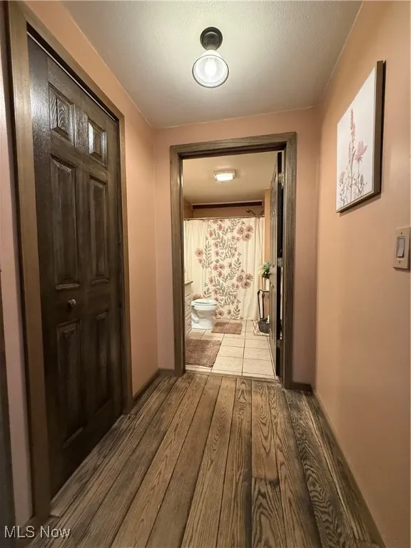 Hallway featuring light wood-type flooring and baseboards
