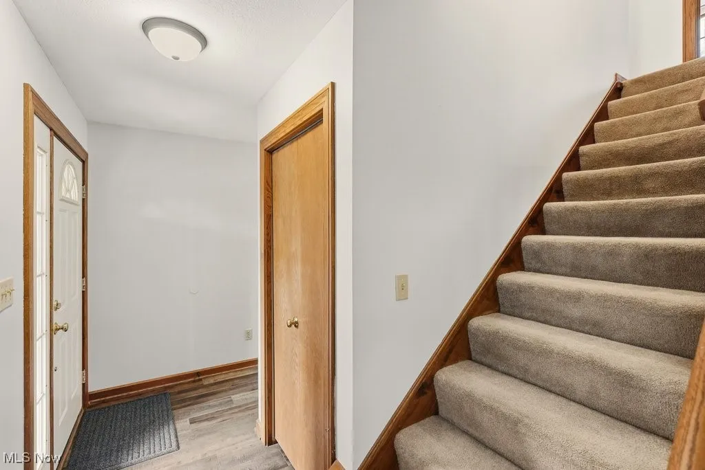 Stairs with wood finished floors and baseboards