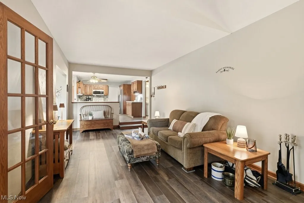 Living room with dark wood-style flooring and ceiling fan