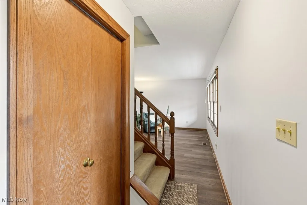 Stairway featuring wood finished floors and baseboards
