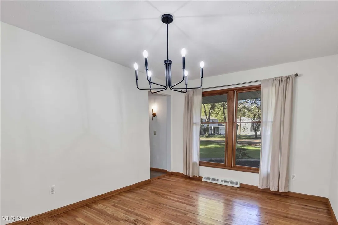 Dining room with fresh paint and wood​​‌​​​​‌​​‌‌​‌‌​​​‌‌​‌​‌​‌​​​‌​​ flooring.