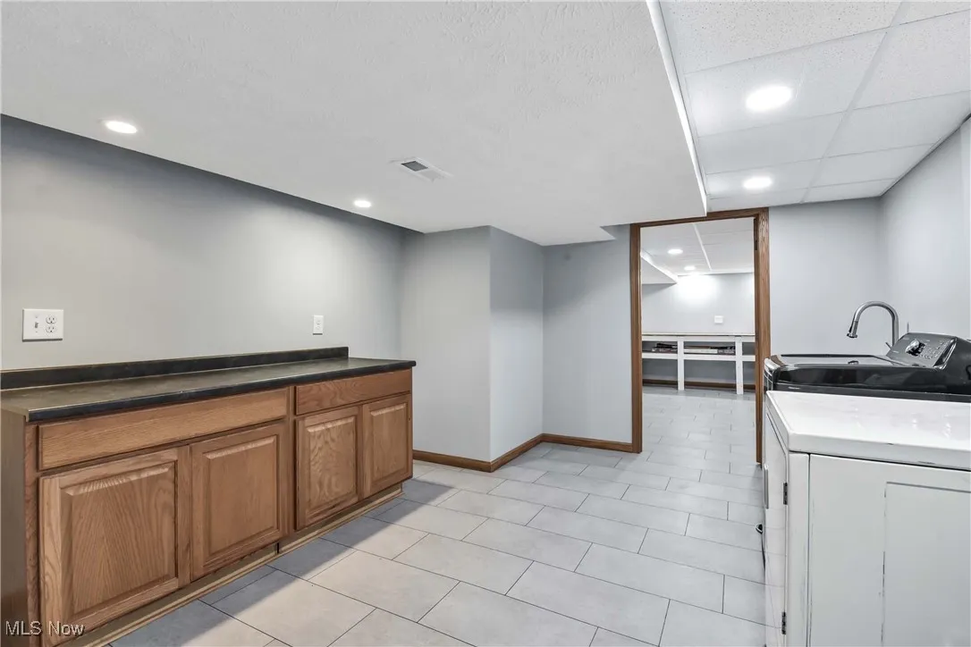 Laundry room leading into a large storage space.