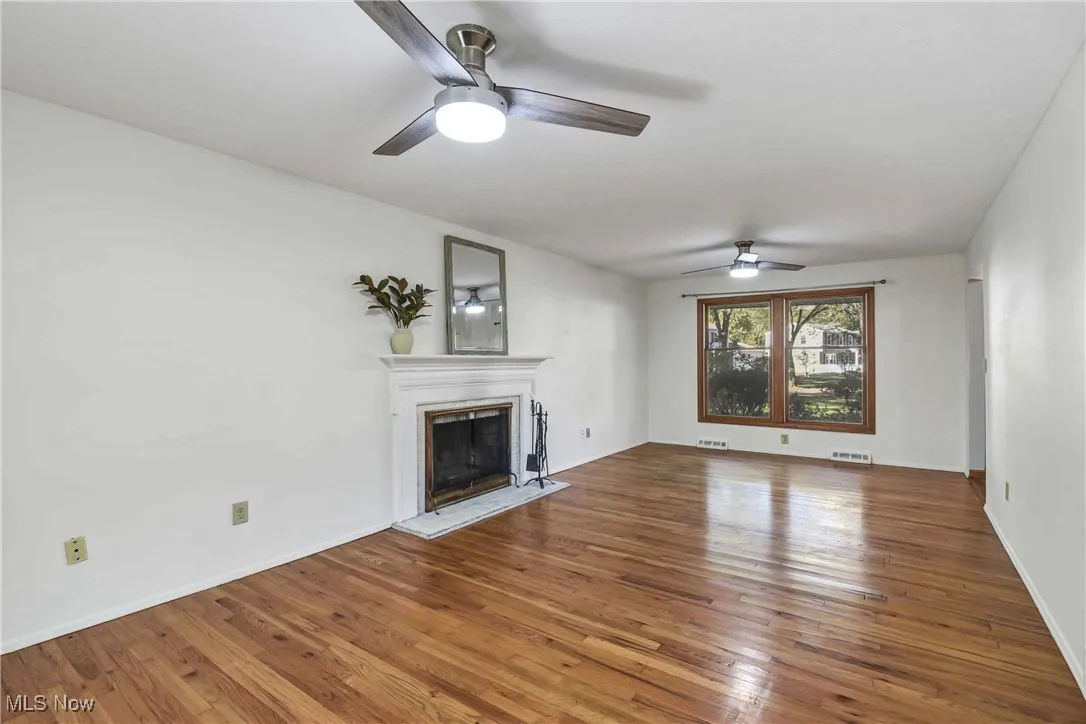 Bright and airy living room with hardwood. flooring and woodburning fireplace