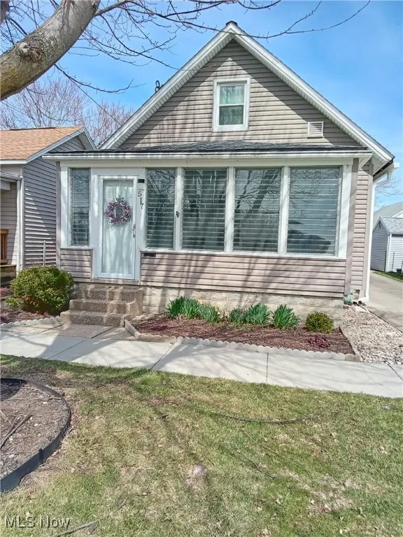 View of front of house in the spring with a front yard and entry steps