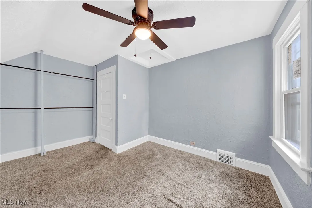Unfurnished bedroom with carpet, a ceiling fan, and a closet