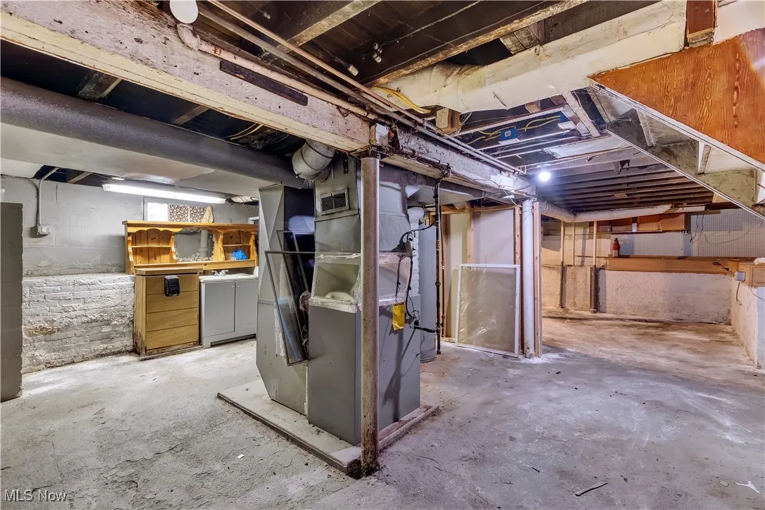 Unfinished basement with heating unit and water heater