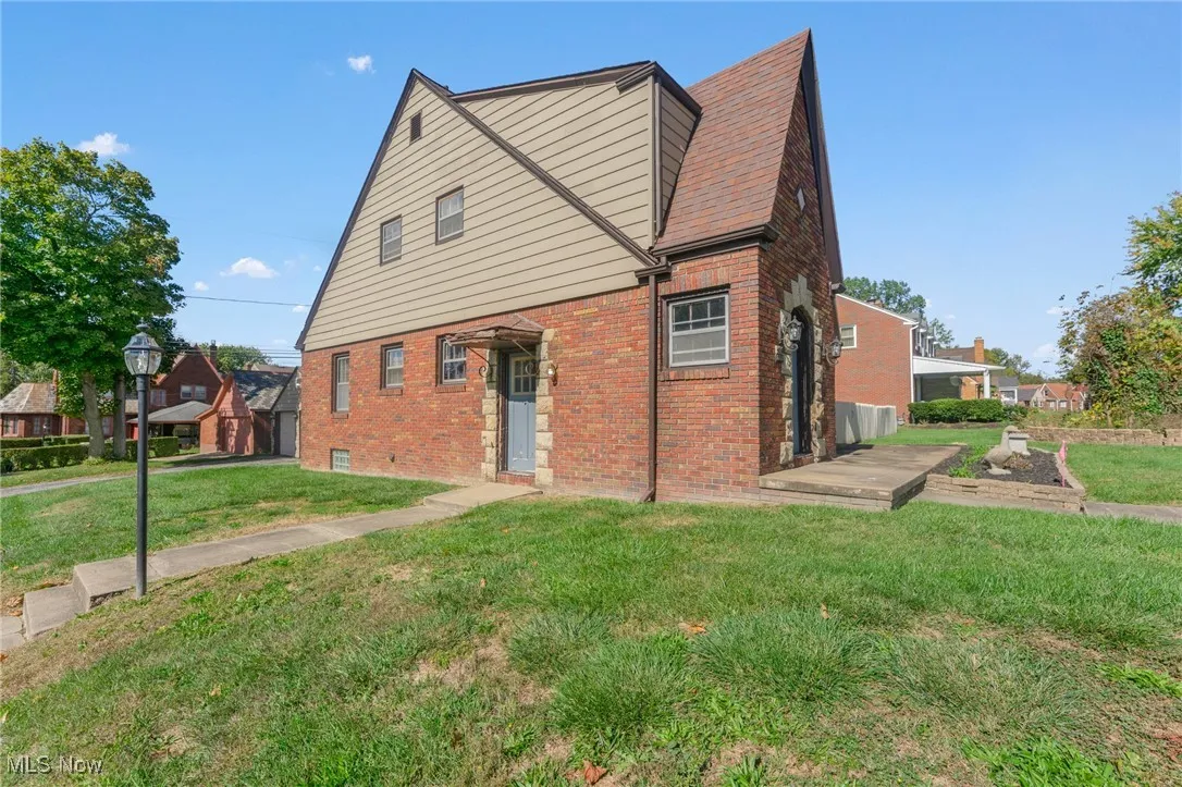 Tudor home featuring brick siding and a front yard