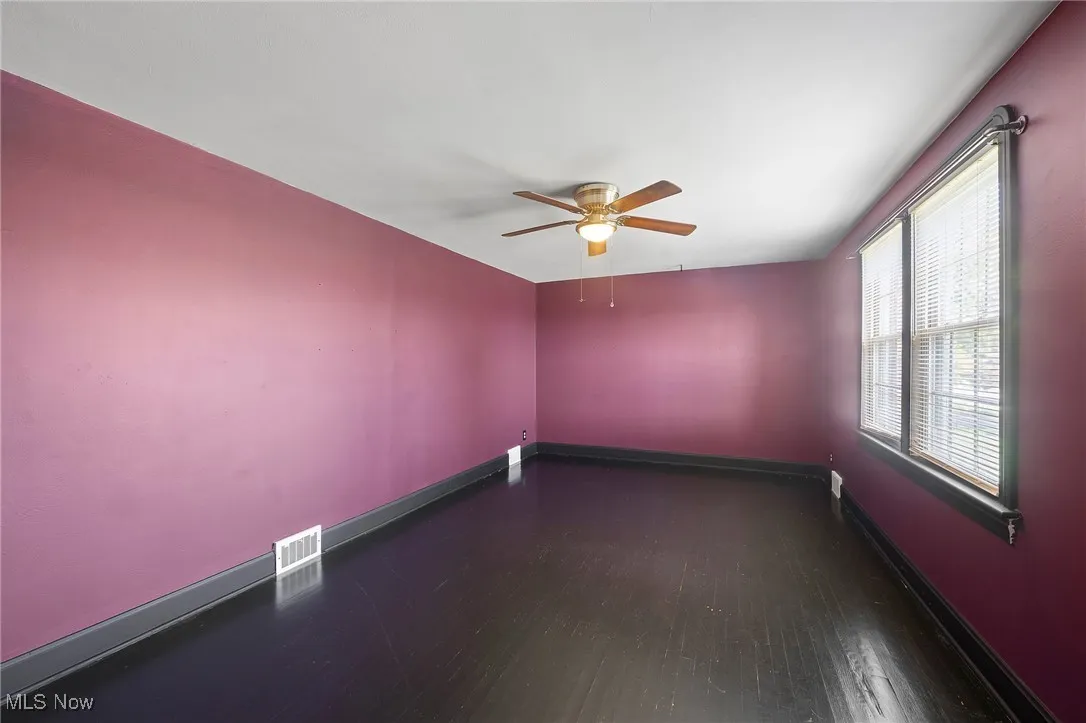 Spare room with dark wood finished floors and a ceiling fan