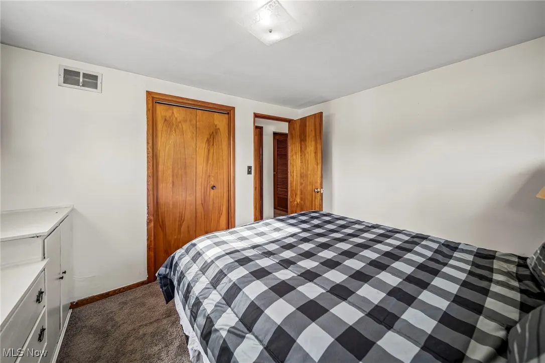 Bedroom featuring a closet and dark carpet