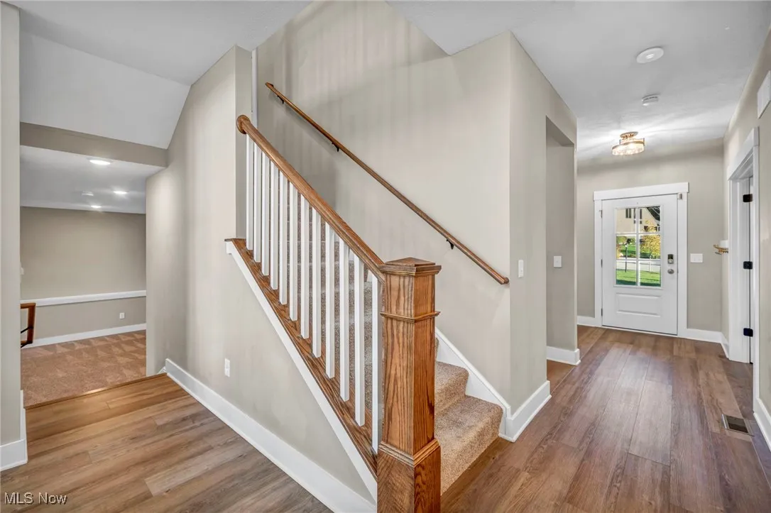 Foyer entrance with wood finished floors, recessed lighting, and stairs