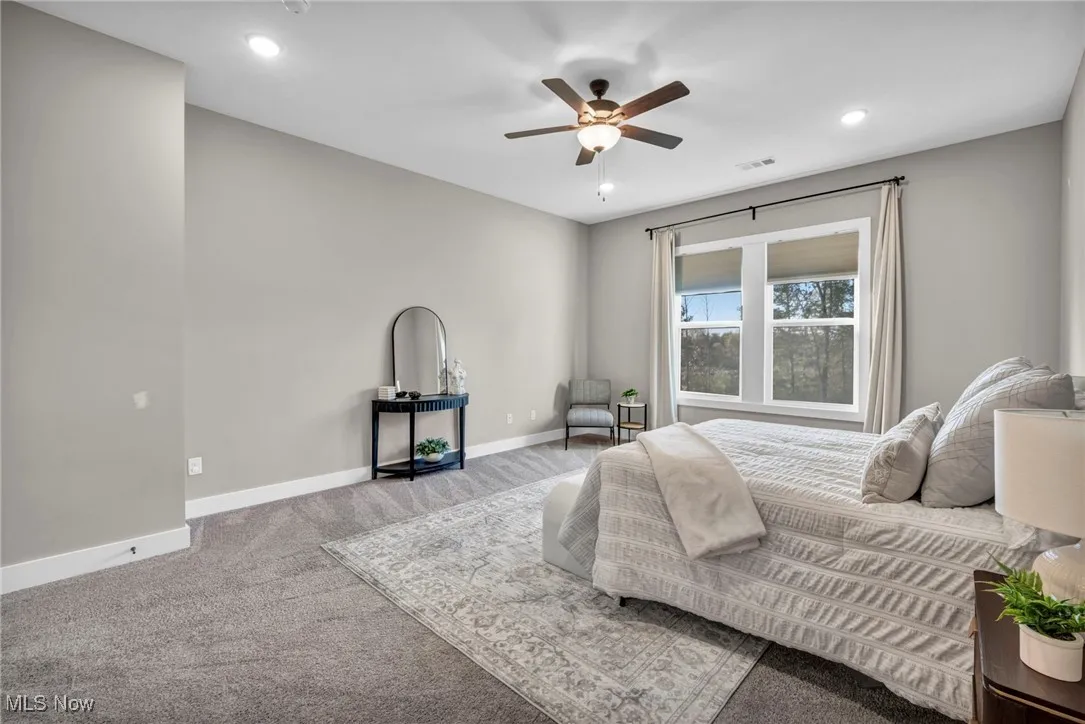 Bedroom featuring light carpet, a ceiling fan, and recessed lighting