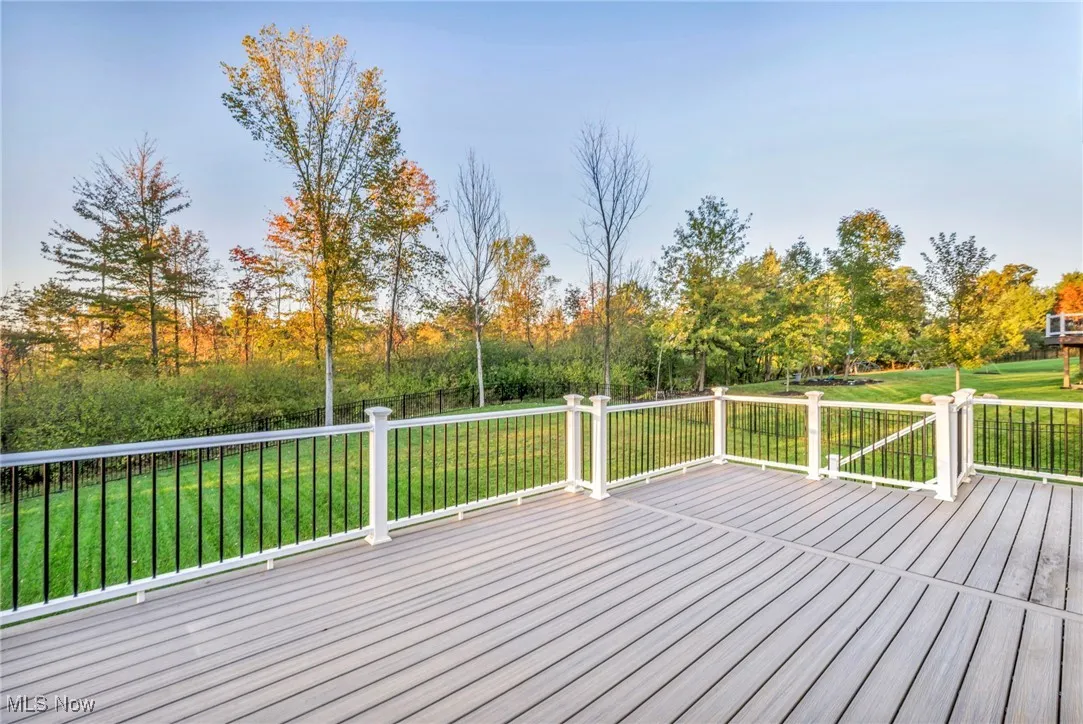 Wooden terrace featuring a yard and view of wooded area