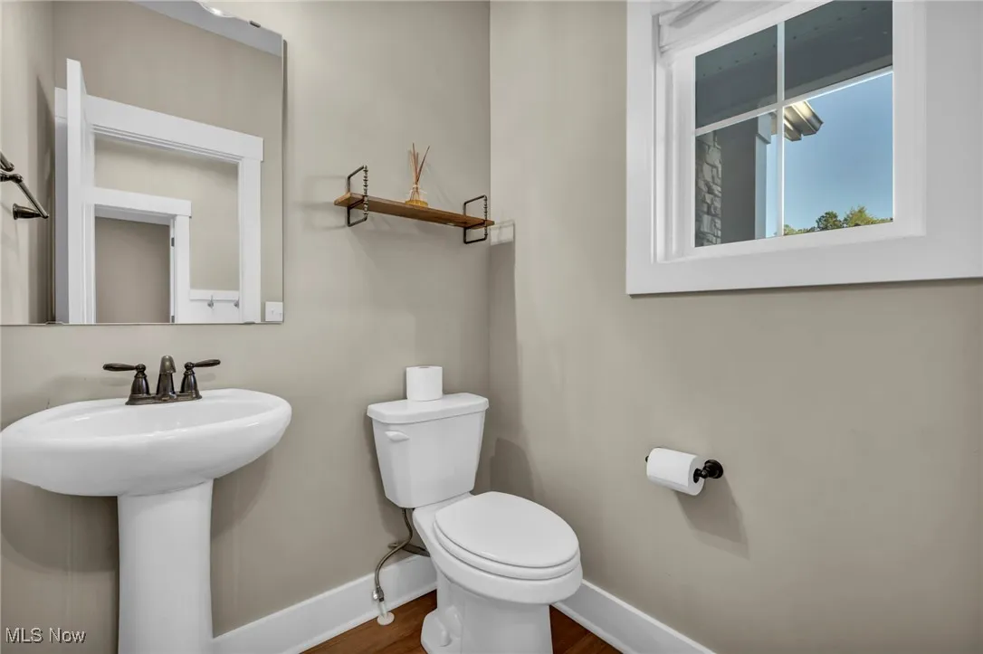 Bathroom featuring baseboards and dark wood-style flooring