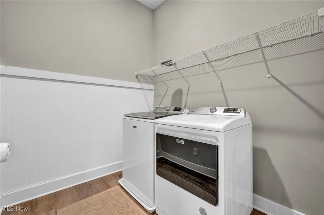 Laundry area featuring wood finished floors and washing machine and dryer