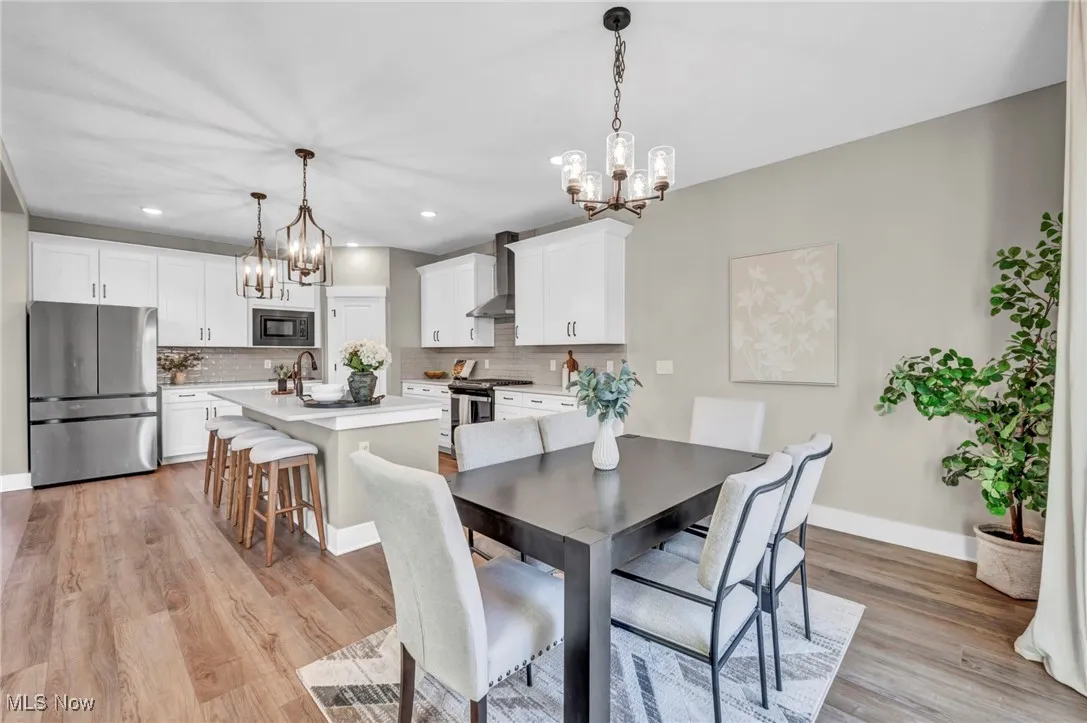 Dining area with a chandelier, light wood finished floors, and recessed lighting