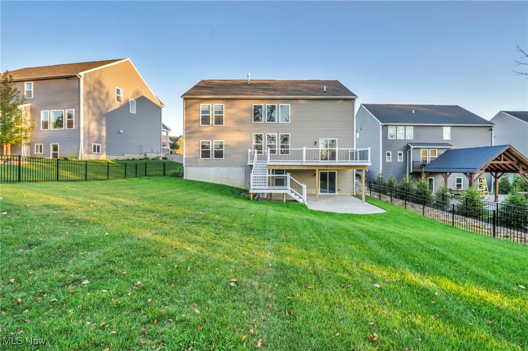 Back of house with stairway, a patio, a deck, and a fenced backyard