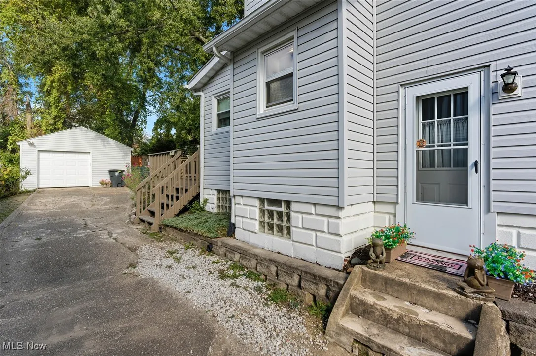 Doorway to property with a garage and driveway