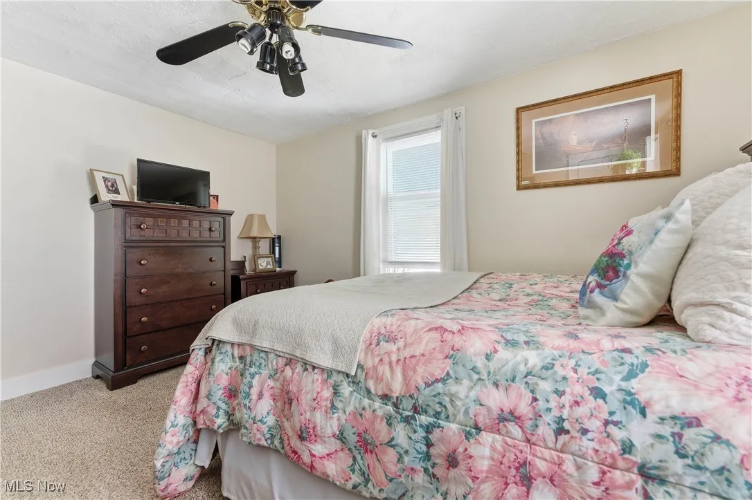Bedroom with light carpet and ceiling fan