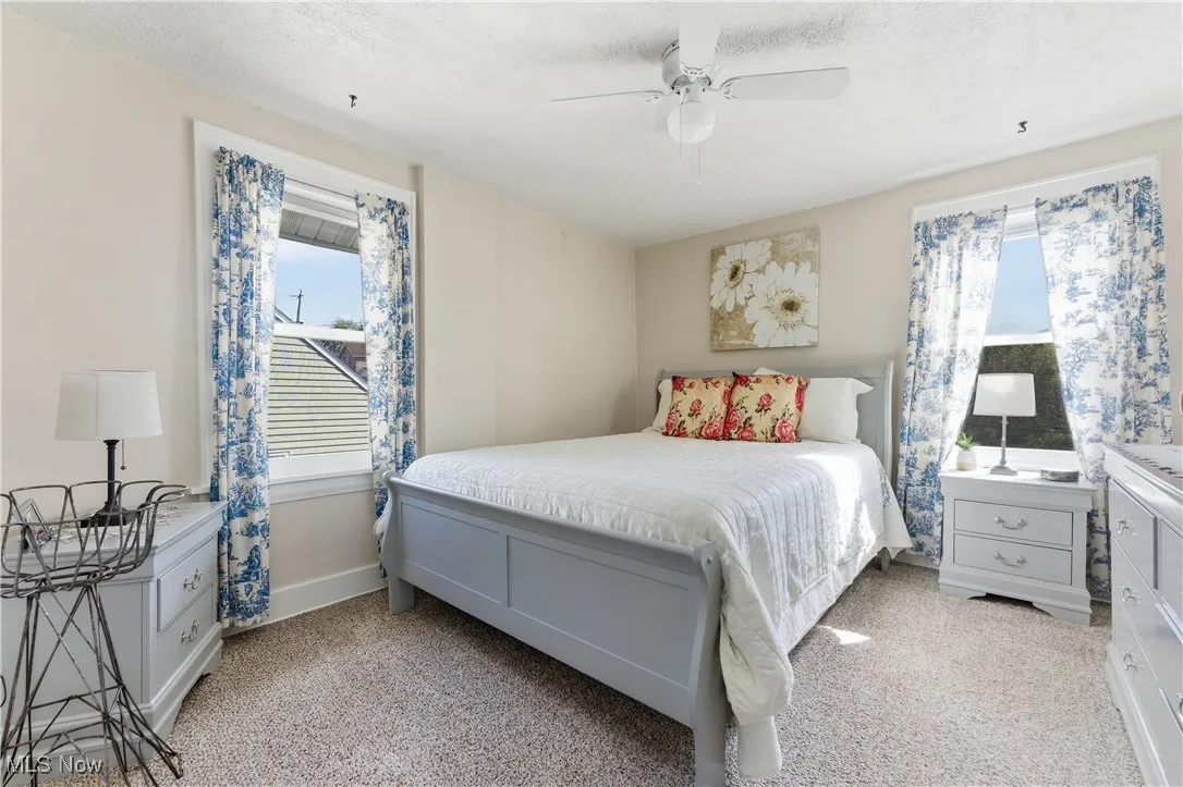 Bedroom with light carpet and a ceiling fan