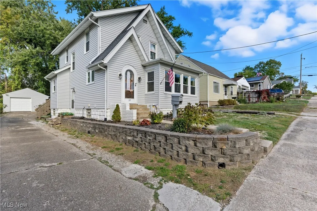 View of side of property with an outbuilding, a garage, and driveway