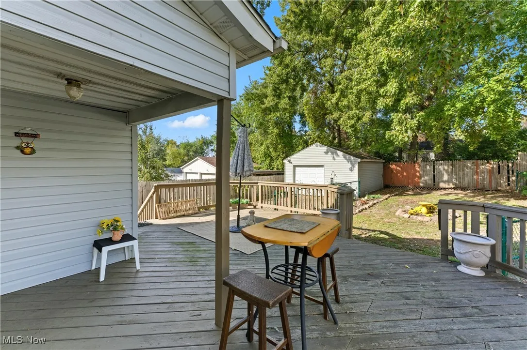 Wooden terrace featuring an outdoor structure and a fenced backyard