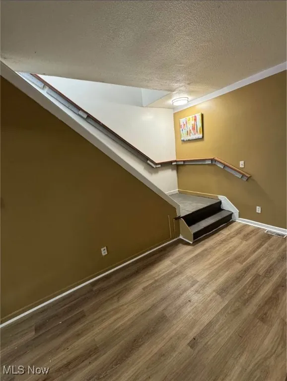 Below grade area featuring a textured ceiling and wood finished floors