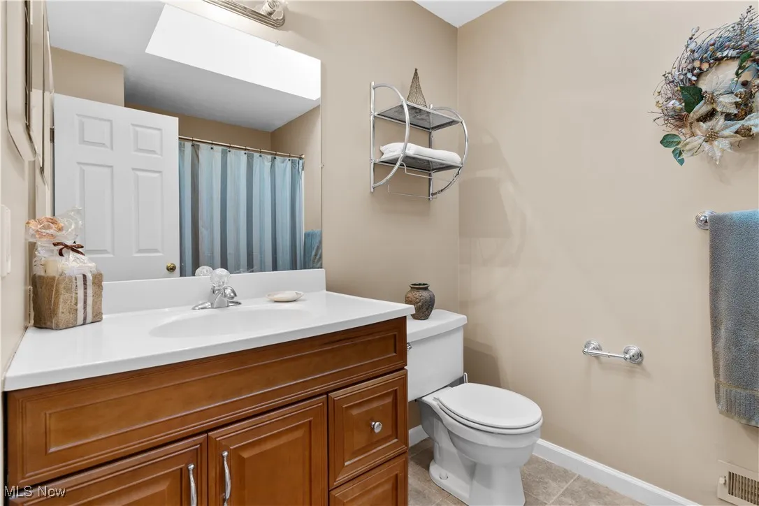 2nd floor Bathroom with vanity, light tile patterned flooring, and curtained shower