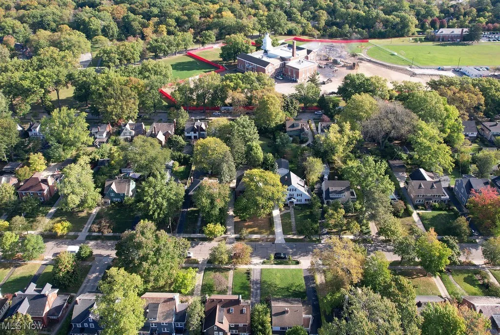 Aerial view of property and surrounding area with nearby suburban area