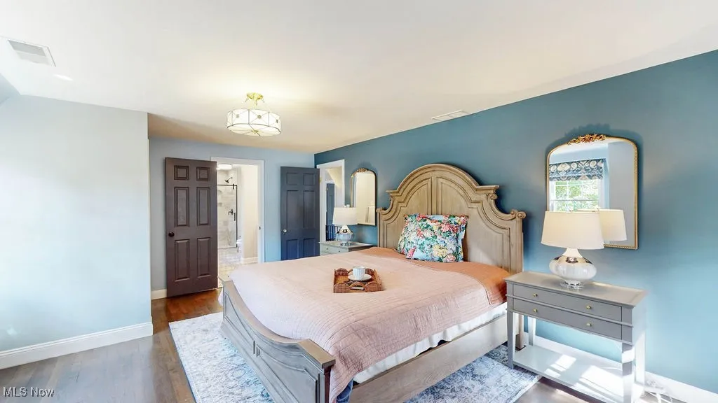Bedroom featuring dark wood-style floors and baseboards