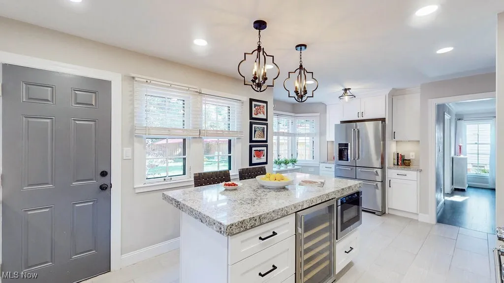 Kitchen featuring white cabinetry, appliances with stainless steel finishes, plenty of natural light, light stone counters, and recessed lighting