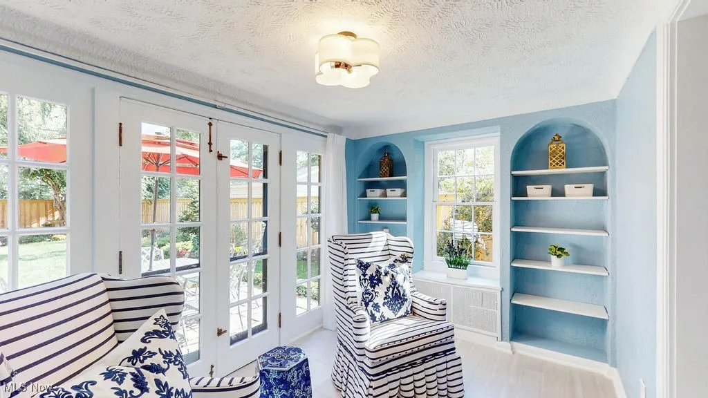 Doorway with a textured ceiling and built in shelves