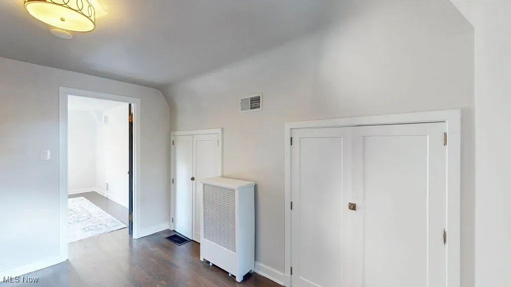 Bonus room featuring dark wood-style floors and baseboards
