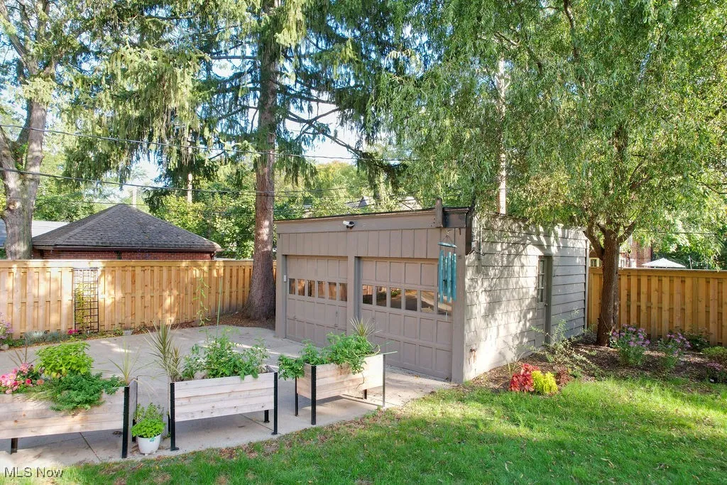 Fenced backyard with an outbuilding, a patio area, and a garage