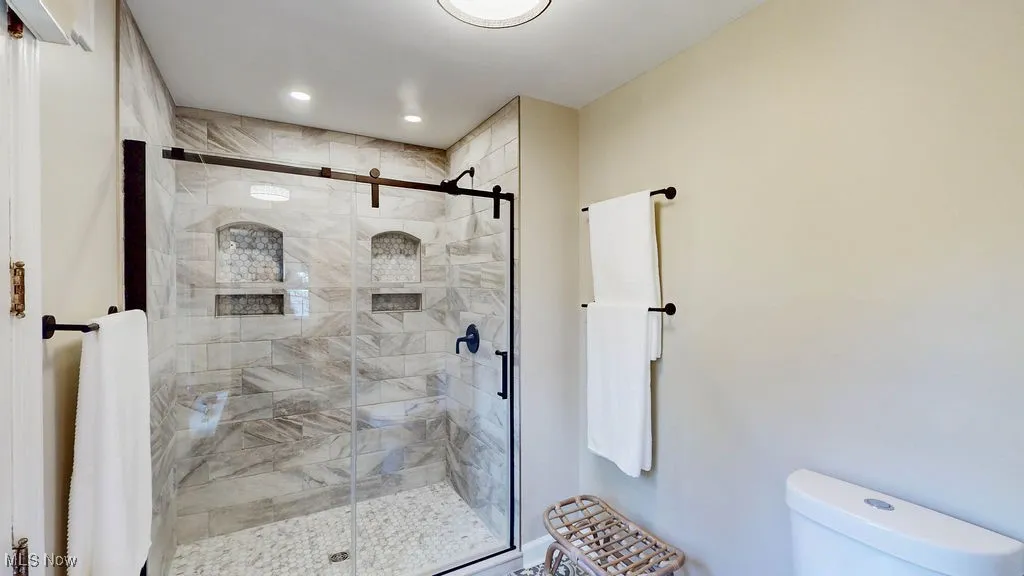 Bathroom with a shower stall and recessed lighting