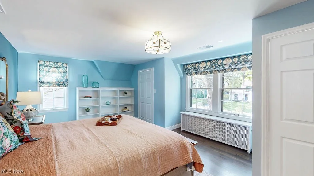 Bedroom with radiator and dark wood-style flooring