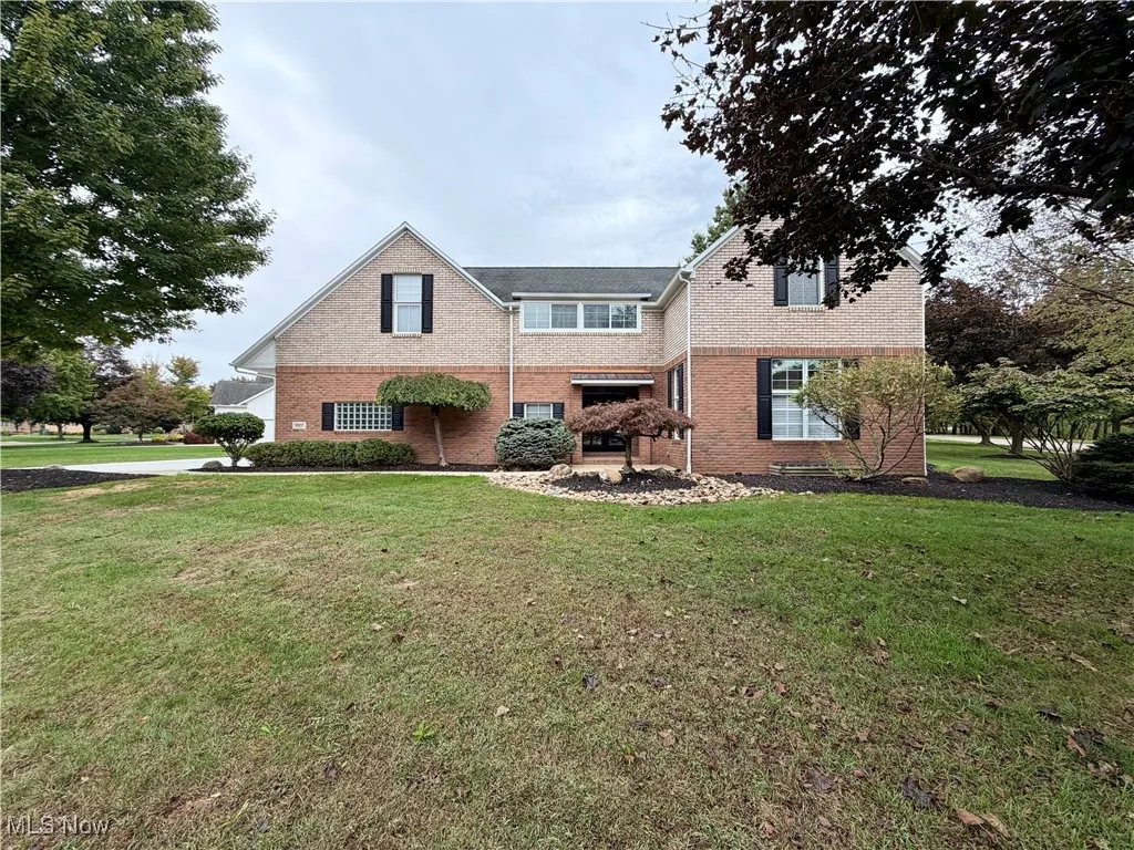 Traditional-style home featuring a front yard and brick siding