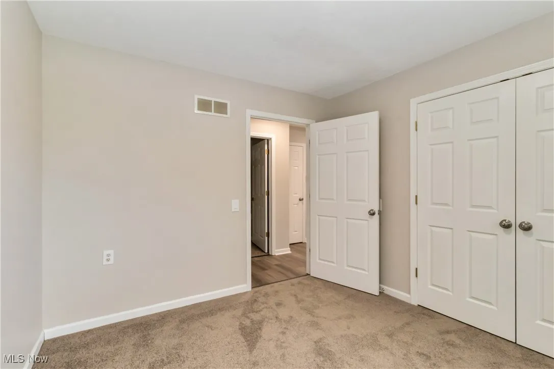Unfurnished bedroom featuring light colored carpet and a closet