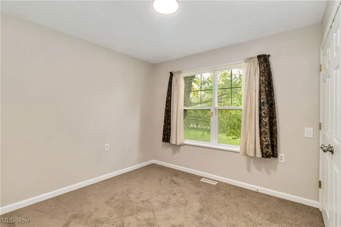 Carpeted empty room with baseboards