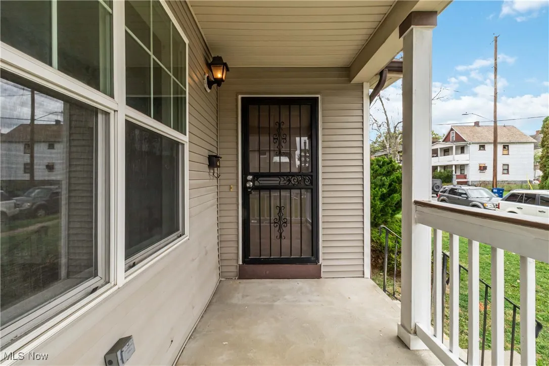 Doorway to property featuring covered porch