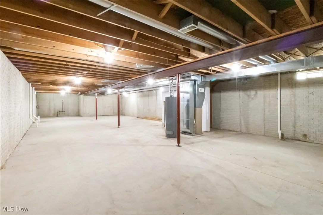 Unfinished below grade area with heating unit and water heater