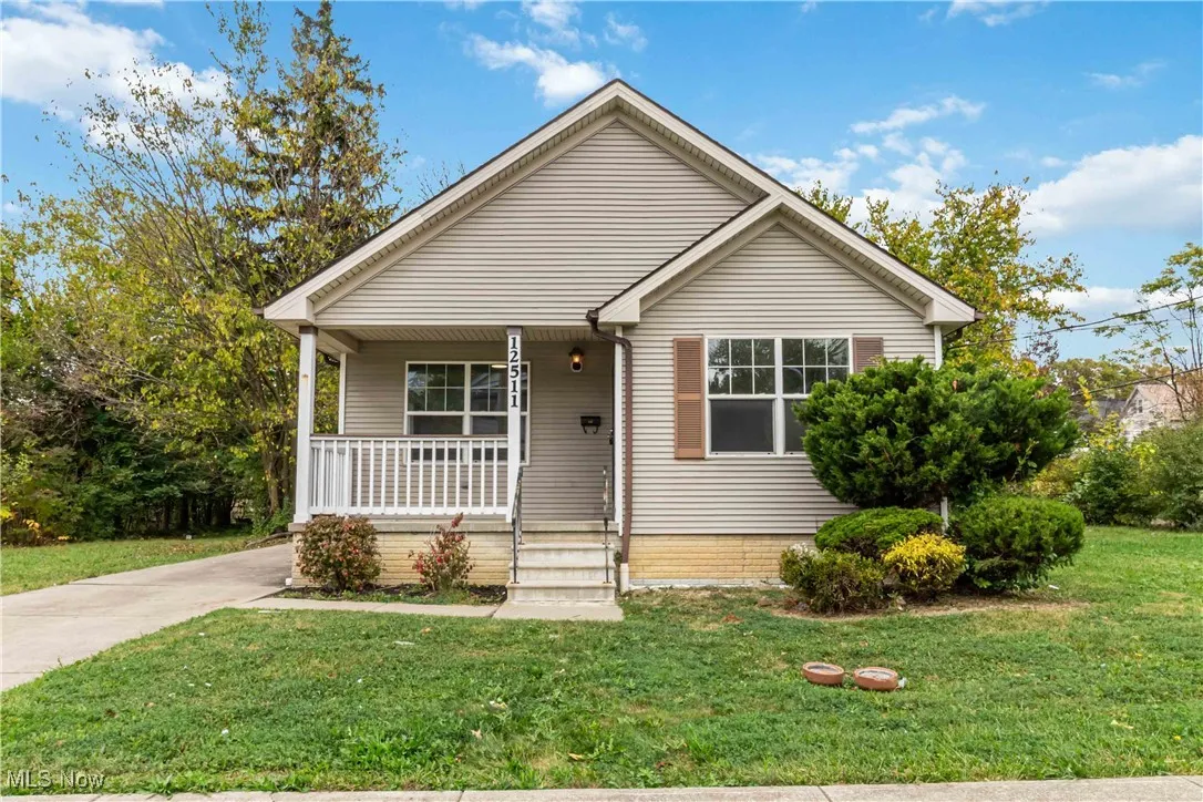 Bungalow-style house featuring covered porch and a front lawn