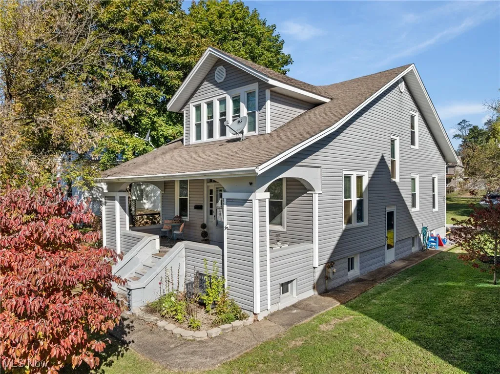 View of front of home featuring a shingled roof, a porch, and a front lawn