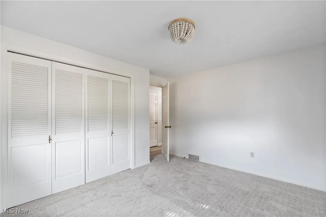 Unfurnished bedroom with carpet flooring and a closet