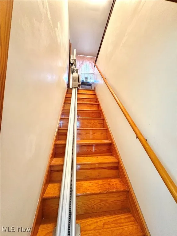 Stairs featuring wood finished floors