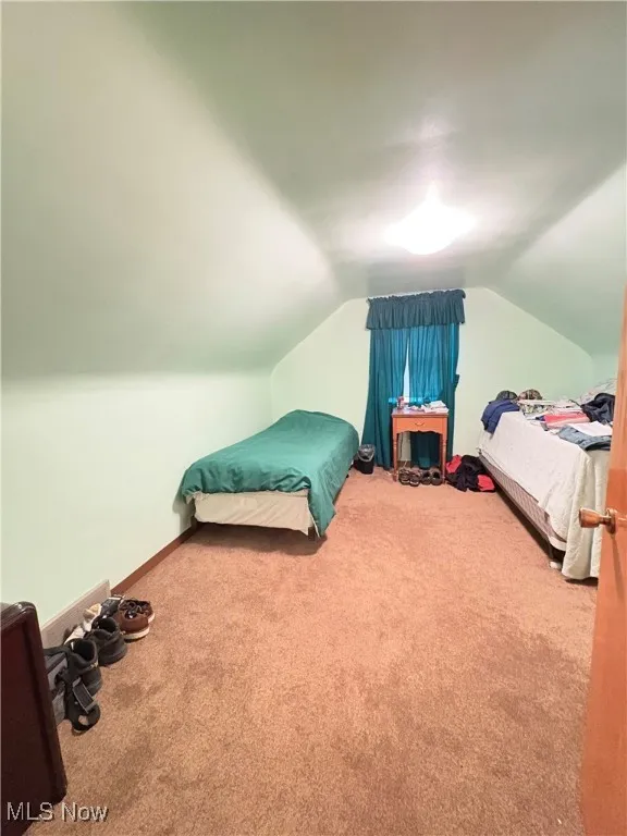 Bedroom featuring carpet flooring and vaulted ceiling